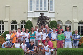 All four LISOT Team Race teams at US Opti Team Race Nationals at Grosse Point Yacht Club in Michigan, including head coach Pepe Bettini (pink shirt next to trophy) and Pablo “Panic” Panichelli (center in front of the statue). © Dixon Pearce