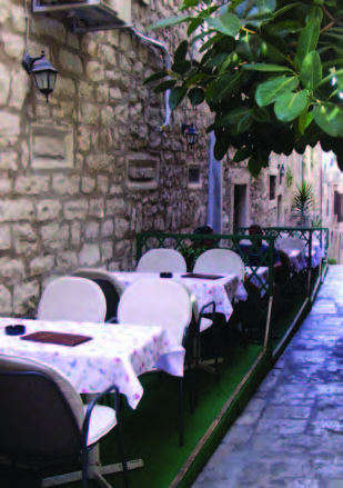 A typically narrow street in Korcula with tables at an outdoor restaurant. Perhaps two feet of “street” remained to the right of the tables!